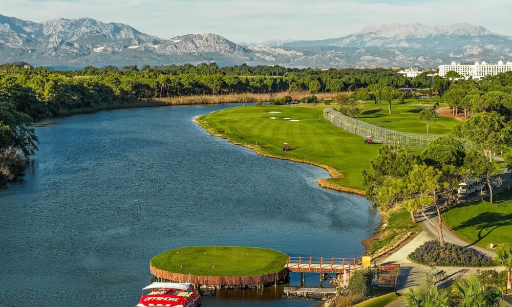Grøn golfbane i Belek med Taurus-bjergene i baggrunden og blå himmel
