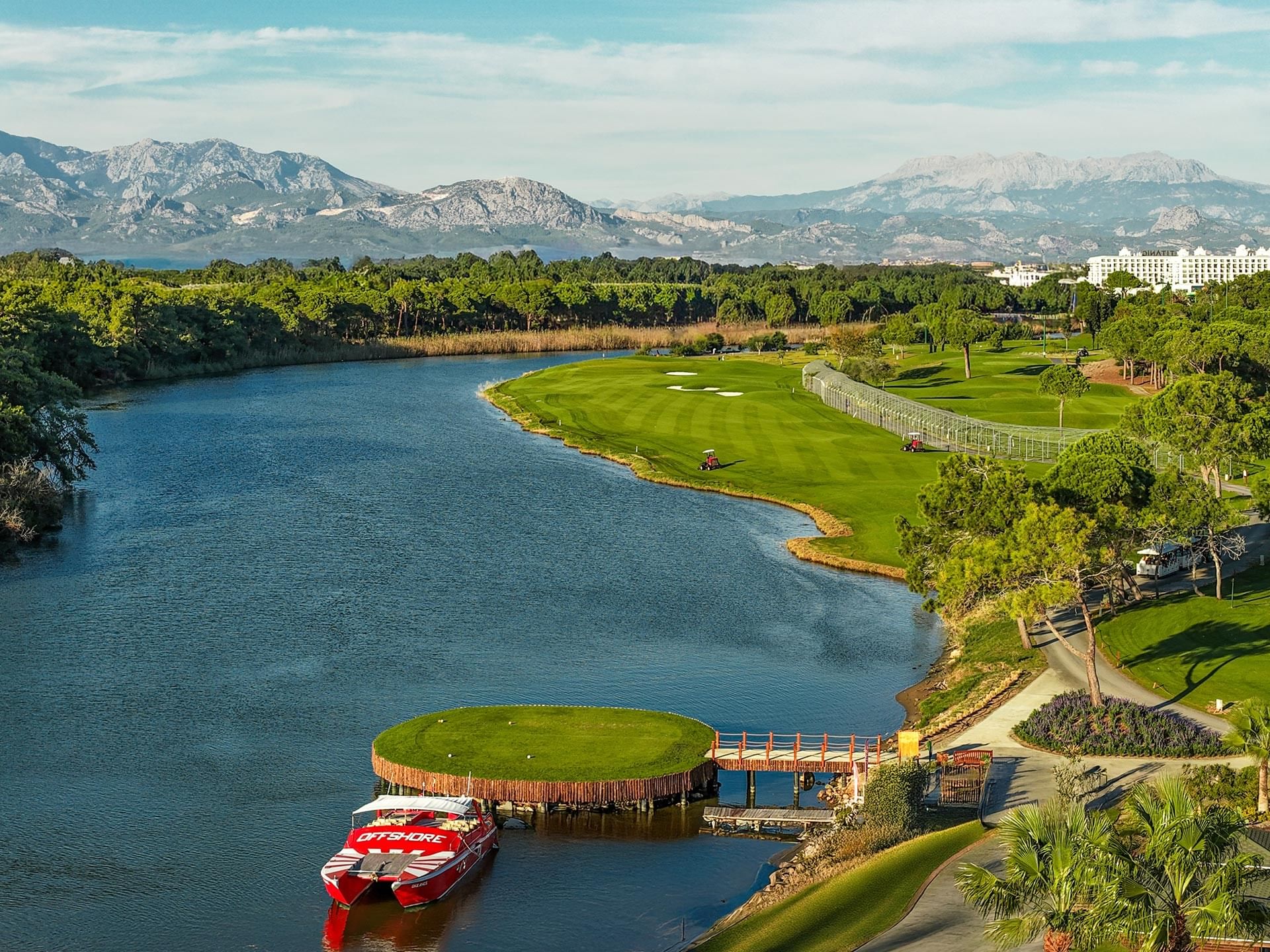 Grøn golfbane i Belek med Taurus-bjergene i baggrunden og blå himmel